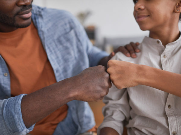 father and son fist bump